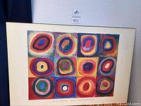 Overall view of the framed print showing the 3x4 grid of colorful concentric rings squares.