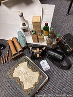 Photo showing entire lot including antique photo album with decorative angel cover, vintage cameras, and medicine bottles