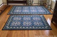 Two rectangular floral-patterned rugs side by side on hardwood floor