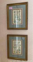 Four framed floral botanical prints hung on wall with light blue mats and ornate gold frames.