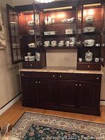 China cabinet displaying multiple Royal Worcester Evesham pieces