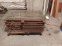 Front view of weathered Maine lobster trap transformed into coffee table with wooden frame and wire netting, topped by clear glass panel.