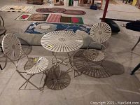 Metal round outdoor table with matching chairs, showing overall set and furniture arrangement