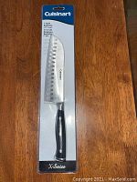 Front view of new Cuisinart 7 inch Santoku knife sealed in original packaging, showing blade and handle.