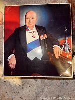 Top view of the antique cookie tin lid showing a formal portrait of Sir Winston Churchill wearing decorations and medals.