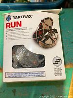 Box label and front of Yaktrax Run traction device packaging showing brand, product name, usage for snow and ice, key features and size fitment.