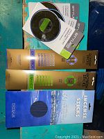 Photo of sealed incense stick boxes in lavender, jasmine, and ocean scents alongside three small round adhesive mirrors.