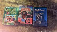 Front view of DVD cases for Night Court Season 1, Dukes of Hazzard Season 5, and Gilligan's Island Season 2 showing cover art and titles.
