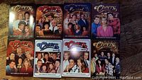 Front cover of Cheers Seasons 1-8 DVD cases, showing cast images and season number