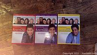 Front view of three DVD box sets of Everybody Loves Raymond Season 1, Season 5, and Season 6 on wooden floor.