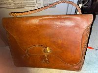 Front view of the brown handmade leather handbag with braided strap and bone toggle lock closure