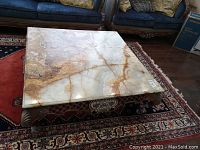 Overall top view of square marble table on area rug