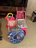 Two baby carriages, a red and yellow ride-on toy car, and the Dream Tents twin size play tent in packaging visible in front.