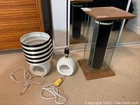 Two desk lamps side by side: one with a black and white striped shade but missing plug, the other with a white rounded base but missing shade.