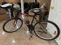 Full side view of black and red Supercycle SC1800 H10 bicycle with steel frame showing the tires, frame, seat, and pedals.