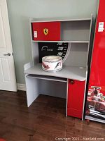 Front view of Ferrari branded wooden desk with red accents, Ferrari logo, and extra shelving.