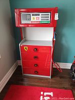 Front view of dresser styled as gas pump showing four drawers, Ferrari logo, pump display, and hose