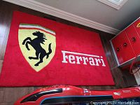 Full view of red Ferrari carpet rug on hardwood floor