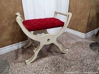 Front and side view of wooden frame seat showing red tufted cushion and curved legs with gold accents.