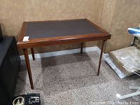 Full view of the wooden folding card table with a dark vinyl top, showing overall structure and size.