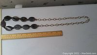 Photo shows a 36-inch dark stone and silver necklace laid out next to a ruler for size reference.
