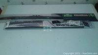 Two winter wiper blades, one in original packaging, one opened and repackaged, displayed on a surface.
