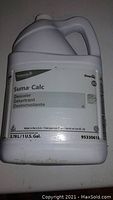 White plastic jug of Suma Calc D5 descaler with label in English and French, showing product volume and safety instructions.