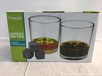 Box front showing whiskey glasses and whiskey stones graphic with FineLife brand and set details
