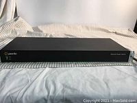 Front view of black Perle RPS820 remote power conditioner bar switch with branding and labeling on a fabric surface.