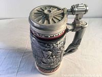 Front view of the Avon ceramic beer stein showing 3D embossed steam locomotive and metal lid with wheel detail
