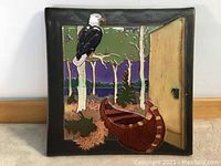 Front view of square hand painted clay tile depicting voyager canoe scene with trees, bird, door, and lake background.