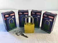 Four boxed ABUS 72/40 model padlocks with one out of the box showing the gold aluminum body and metal shackle along with two keys.