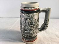 Side view of the embossed vintage Avon train mug showing detailed Union Pacific 1941 and The General 1855 trains with the sculpted handle shaped like a boot.