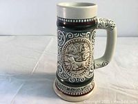 Photo of vintage 1983 Avon ceramic mug depicting an English Setter in relief on one side, with ornate scrollwork and patterned bands.