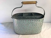 Front/side view of the unique aluminum bucket showing textured geometric exterior and wooden handle