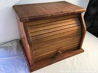 Front angle view of vintage handmade solid wood roll top bread box showing curved slatted roll-top door and wooden knob