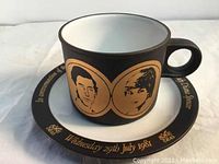 Photo of the vintage Hornsea commemorative cup on the matching saucer showing portraits and gold text