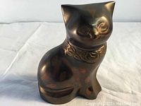 Front right view of the brass cat statue showing floral engraving on the collar, antique patina and smooth surface.