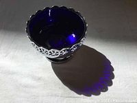 Top view of cobalt blue glass dish in silver plated pedestal with scalloped edge.