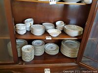 Photo showing all listed dishes including the soup bowls, salad bowl, cups, saucers, and plates arranged in a cabinet.