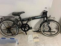 Side profile of folded bicycle showing frame, wheels, racks, kickstand