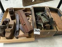 Overall view of wooden hand planes, saw, and box with hardware showing the lot contents
