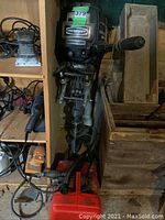 Mercury outboard motor and red fuel tank side by side on shelf with surrounding tools