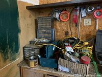 Sectional storage cabinets with multiple small drawers containing nuts, bolts, and washers. Various hand tools and accessories placed on top and around the cabinets.