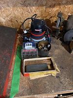 Craftsman router with bits, sharpening stone, wrench on wooden surface
