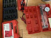 Pressure gauge and accessories in red molded plastic case with dial and attachments