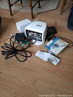 Wide view showing Jabsco searchlight head, wiring harness, remote control packaging, Lorex monitor and cables on floor