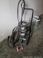 Full view of Briggs and Stratton pressure washer with hoses, spray gun, and tips on carpeted floor.