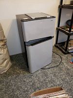 Fridge showing gray front with freezer on top in closed state