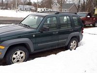 Driver side profile showing green SUV in snow